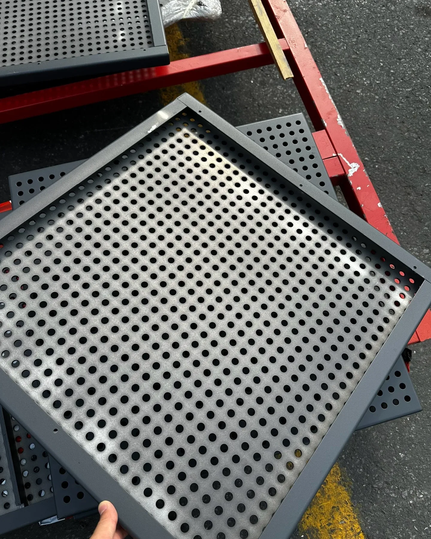 Framed round-hole perforated metal ceiling panel viewed close up